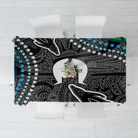 Folded tablecloth showing black base with white and teal dot-and-line tribal pattern.