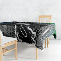 Black, white and teal patterned tablecloth draped over wooden bench at the corners.