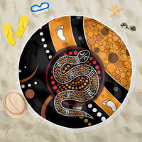 Round beach blanket with fringed edge, black and orange Aboriginal snake dot art