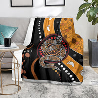 Multicolor snake dot art blanket on floor with black, orange, and paw print details.