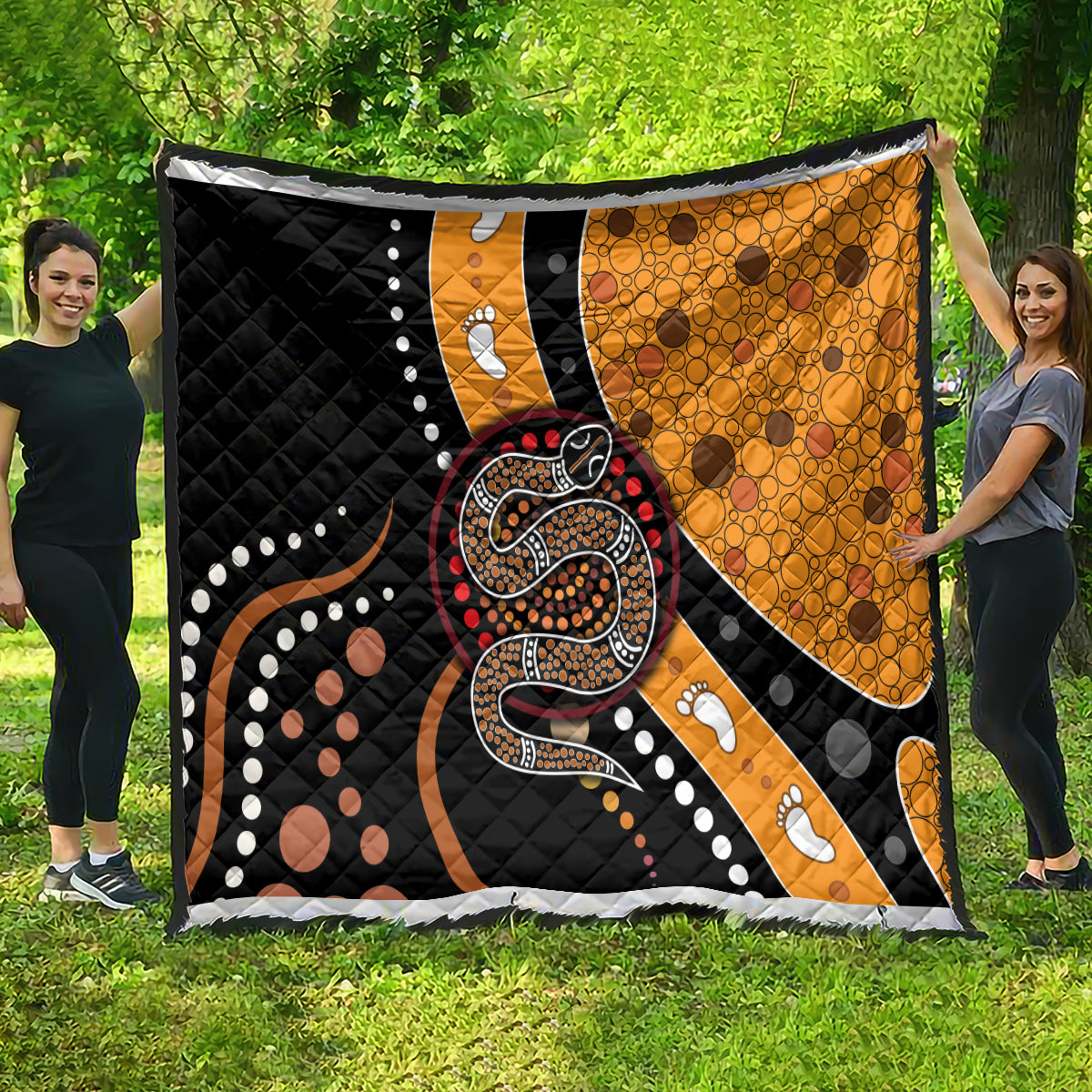 Oversized snake dot art quilt featuring black and orange panels with paw-print details