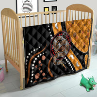 Child bed quilt with black and orange snake design, white dots, and paw-print accents