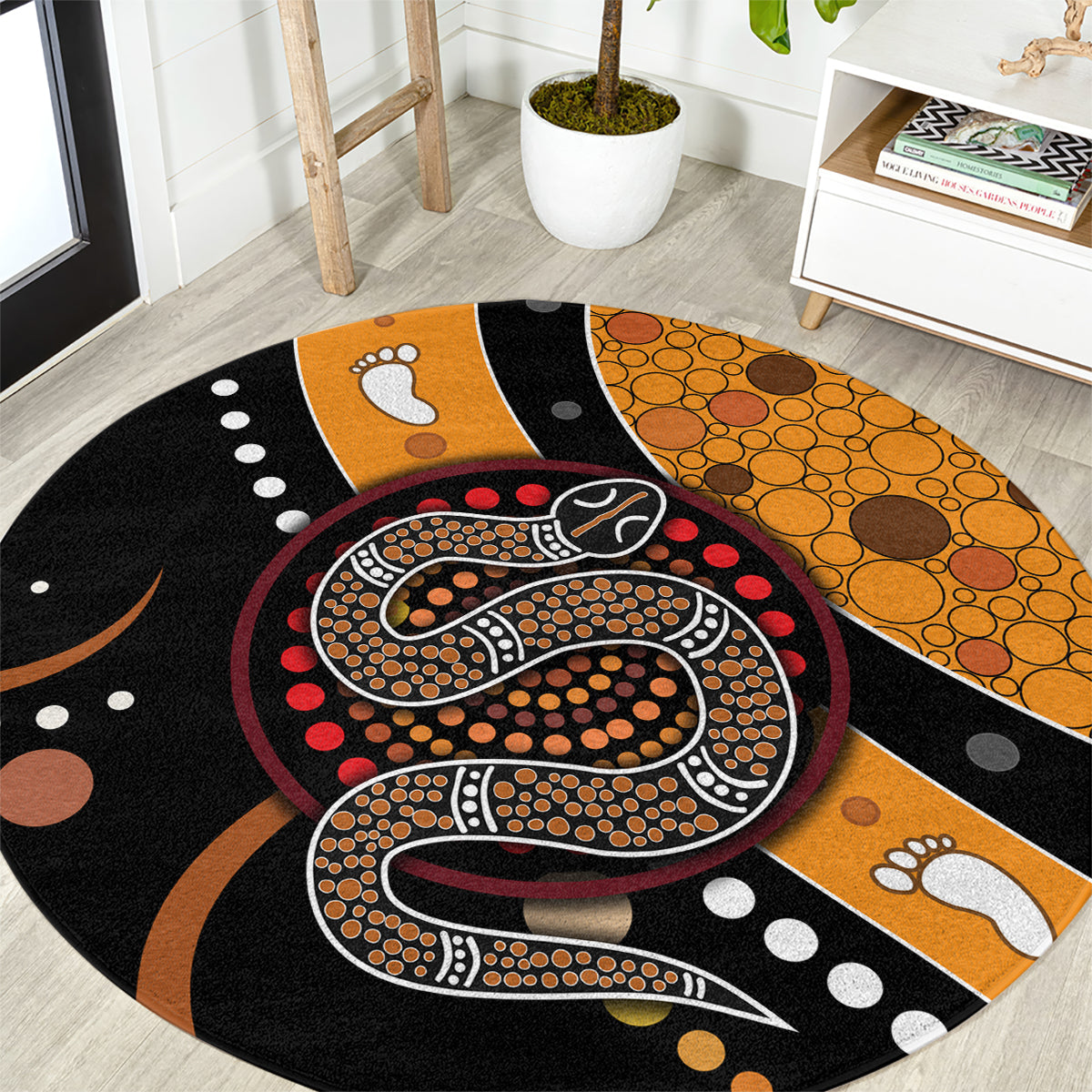 Round area rug with black, orange and multicolor Aboriginal snake dot art pattern