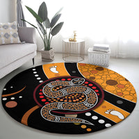 Round area rug featuring a large Aboriginal snake dot design in black, orange and red