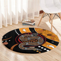 Round area rug with Aboriginal snake dot art, orange and black geometric shapes