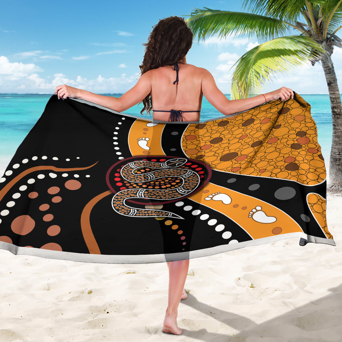 Black and orange dot-pattern sarong featuring a snake design, shown from behind.