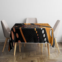 Multicolor snake dot art tablecloth on dining table, black-orange top with circular dot pattern