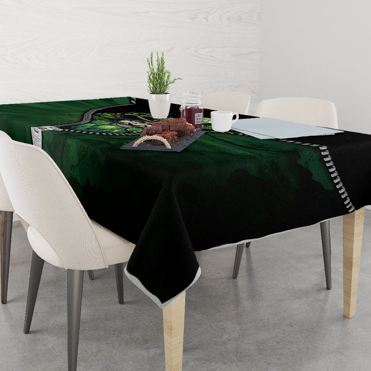 Green and black 3D zip-art tablecloth on a dining table with a central multicolor graphic.
