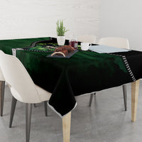Green and black 3D zip-art tablecloth on a dining table with a central multicolor graphic.