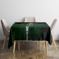 Green and black 3D zip-art tablecloth on a square table with zipper-style graphic in center.
