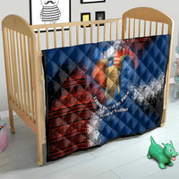 Blue quilt with red tribal border and elephant graphic, placed in wooden baby crib