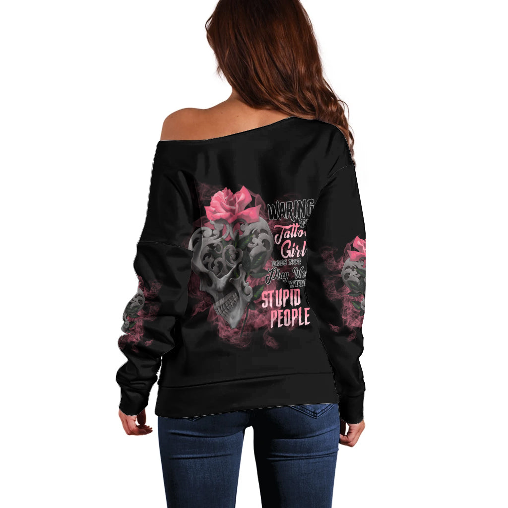 Black off-shoulder sweater with long sleeves and skull rose graphic on back