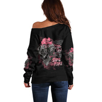 Black off-shoulder sweater with long sleeves and skull rose graphic on back