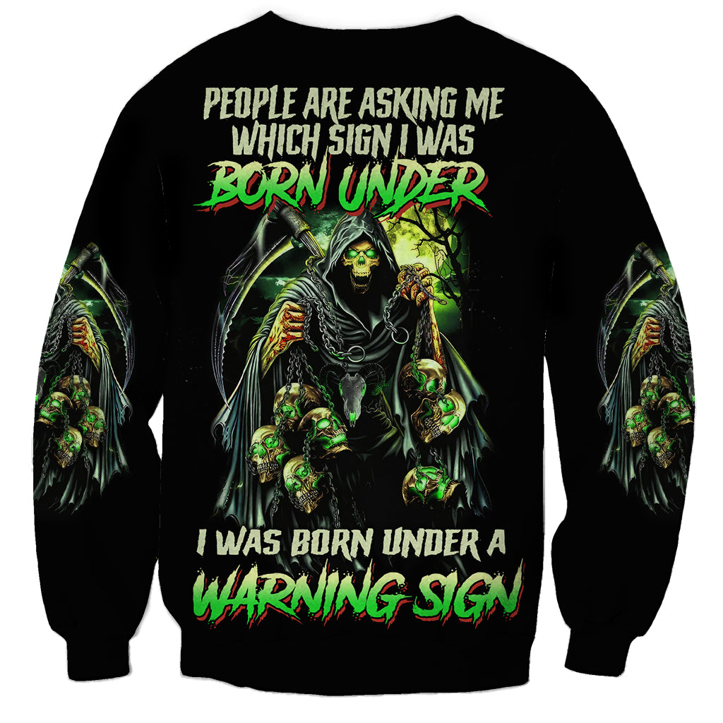 Black sweatshirt with green reaper skull graphic and bold warning sign text