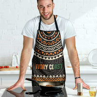 Apron with dark geometric print and 'IVORY COAST' text, black neck and waist straps