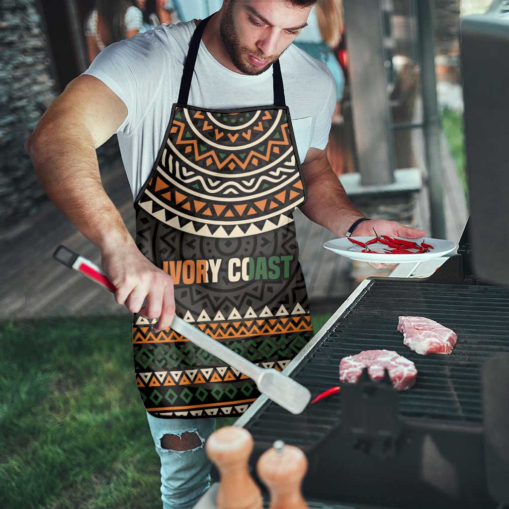Apron with dark geometric bands and 'IVORY COAST' motto, black neck strap