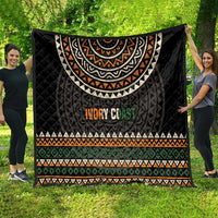 Black quilt with large geometric arc motif, multicolor stripes, and “Ivory Coast” text