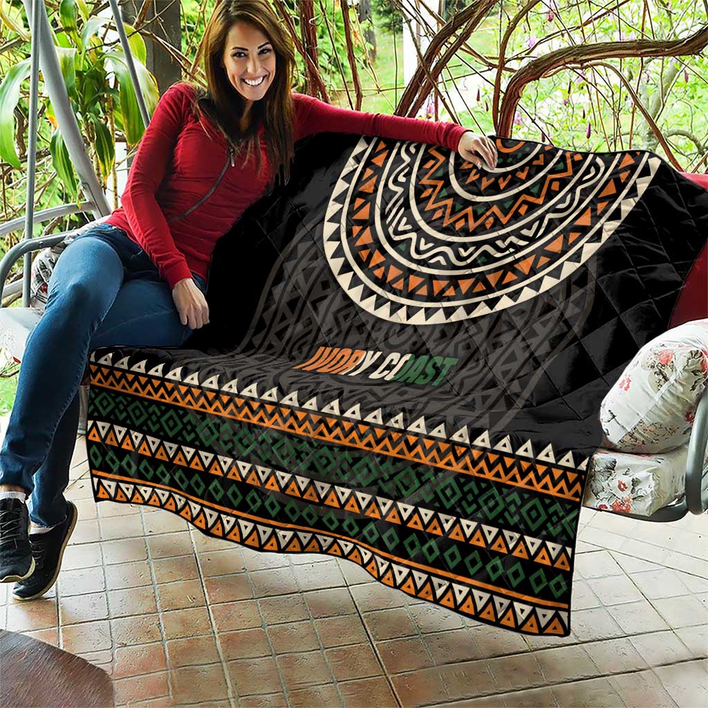 Black quilt with large geometric arc print, multicolor stripes, and “Ivory Coast” text