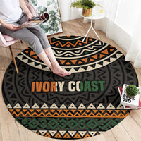 Round area rug with geometric pattern and “IVORY COAST” lettering in orange and green