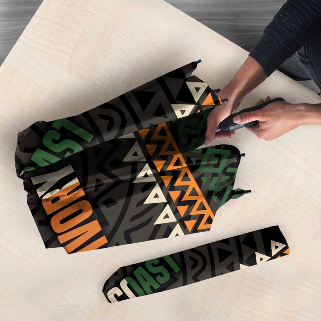 Folded umbrella with black geometric print, 'IVORY COAST' lettering, and patterned edge