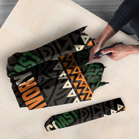 Folded umbrella with black geometric print, 'IVORY COAST' lettering, and patterned edge