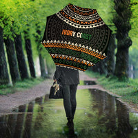Umbrella with black canopy, multicolor geometric stripes, and 'IVORY COAST' badge