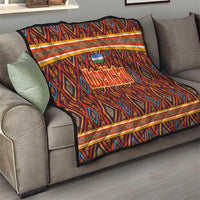 Multicolor Uzbekistan quilt on gray sofa, with geometric diamonds and orange border