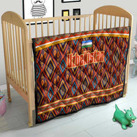 Multicolor Uzbekistan quilt on baby crib, with diamond motifs and flag emblem