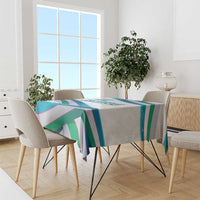 Multicolor ribbon-wave tablecloth draped on dining table with chairs and straight edge.