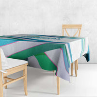 Multicolor ribbon-wave tablecloth with geometric stripes over a table edge.