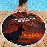 Round beach blanket with fringe, horse silhouette over red desert print and NEBO text