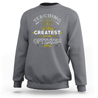 Charcoal gray crewneck teacher sweatshirt with “Teaching is the Greatest Act of Optimism” graphic