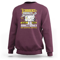 Maroon crewneck sweatshirt with front “Ecommerce Manager” graphic and text.