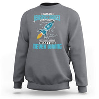 Charcoal gray crewneck sweatshirt with colorful astronaut graphic and tech-style text print