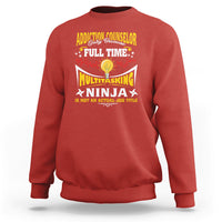 Red sweatshirt with colorful “Addiction Counselor” and “Multitasking Ninja” text graphic.