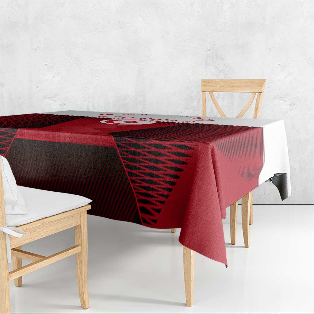 Red and black patterned Tunisia tablecloth with crest, showing hanging edge