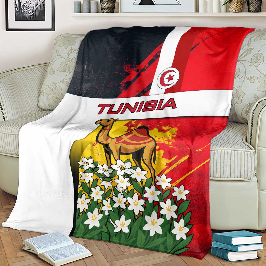Tunisia blanket folded on a couch showing camel and jasmine flowers with Tunisia flag design