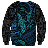 Black unisex sweatshirt with teal whale illustration, blue compass-style circle on front