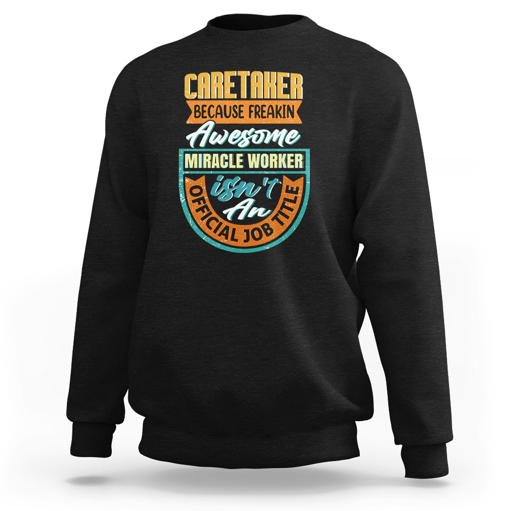 Black crewneck sweatshirt with colorful “Caretaker” miracle worker graphic