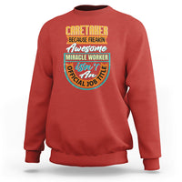 Red crewneck sweatshirt with colorful “Caretaker” miracle worker graphic