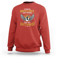 Red sweatshirt with “Never Underestimate” auctioneer graphic on the chest