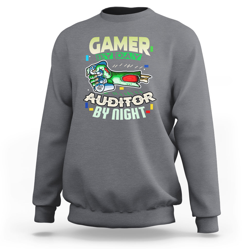 Charcoal gray crewneck sweatshirt with “GAMER BY DAY” and “AUDITOR BY NIGHT” chest graphic.