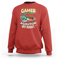 Red crewneck sweatshirt with “GAMER BY DAY” and “AUDITOR BY NIGHT” chest graphic.