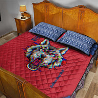 Red quilt bed set with blue patterned pillows/shams and colorful wolf face design