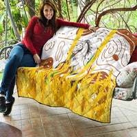 Multicolor quilt draped over couch with white base, brown swirl lines, gray horse, and yellow highlights