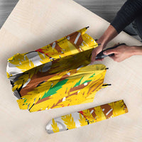Folded umbrella with white, brown, and yellow abstract design