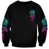 Black crewneck sweatshirt with small teal rose graphic and purple smoke accents