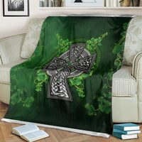 Green Irish cross and shamrock floral blanket on an armchair, close view of cross design