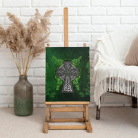 Green canvas wall art of Celtic cross with shamrock leaves displayed on easel