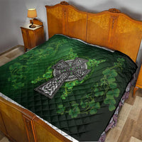 Dark green quilt on bed with Celtic cross emblem and shamrock floral vines in green